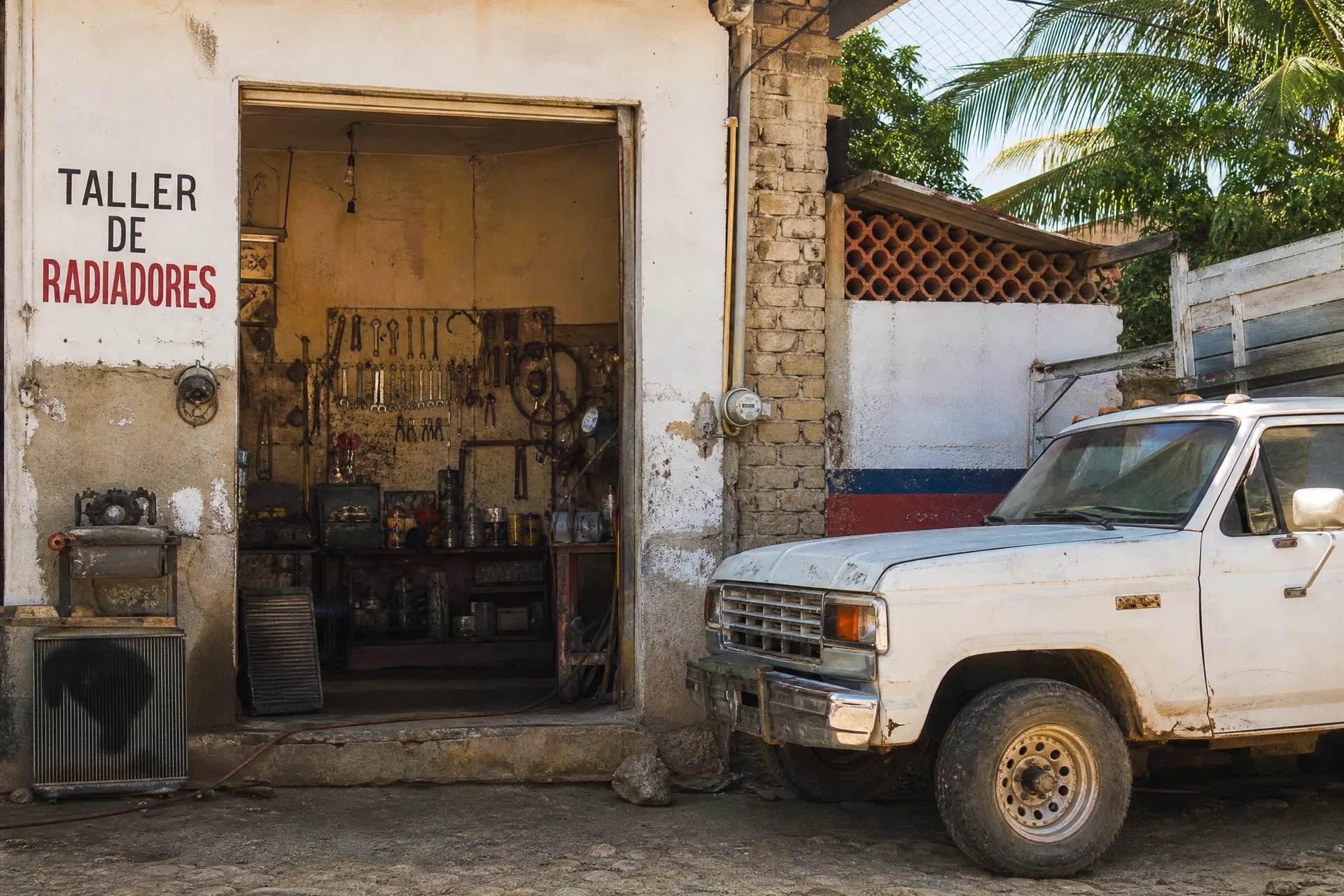 Taller de radiadores con herramientas y una camioneta estacionada